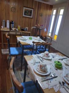 邦雅尔丁-达塞拉Pousada Vivenda das Flores Ltda的一间用餐室,配有餐桌和餐具