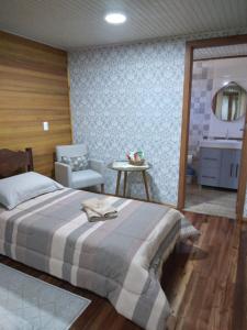 邦雅尔丁-达塞拉Pousada Vivenda das Flores Ltda的一间卧室配有一张床、一把椅子和一个水槽
