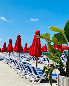 阿莱曼PORTO MARINA North Coast -الساحل الشمالي بورتو مارينا العلمين的海滩上的一组椅子和遮阳伞