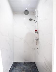 Opoa欧帕海滩酒店的一间设有白色大理石墙壁和淋浴的浴室