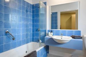 斯特拉恩斯特拉恩汽车旅馆的蓝色瓷砖浴室设有水槽和淋浴