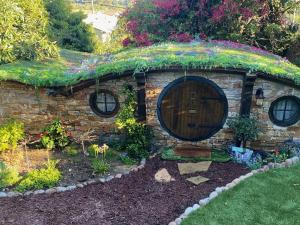 圣巴巴拉Hobbit Haven的花园中带门的小石头房子