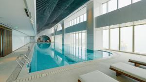 青岛青岛钓鱼台酒店的一座大型游泳池,位于一座带窗户的建筑内