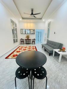 哥打巴鲁Dhuha & Dharyl's Staycation的客厅配有桌子和沙发