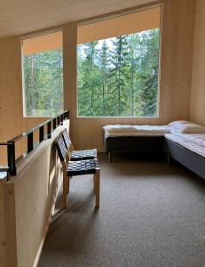 于韦斯屈莱Havu Resort Laajavuori, a calm and peasefull place in the forest near city的客房设有两张床、一张长凳和两个窗户。