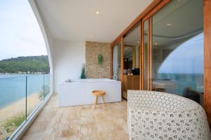 卡农Elite Atoll Khanom - Luxury Coastal Escape的带浴缸、桌子和椅子的浴室