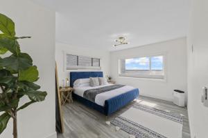 Driftwood ShoresNew DRIFTWOOD SHORES ROAD HOUSE CAMANO的白色卧室设有蓝色的床和窗户