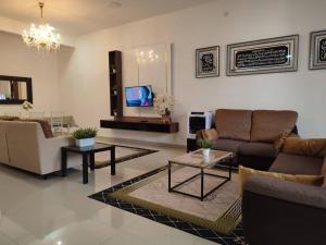 新山Dhana Palace Homestay Gelang Patah的带沙发和桌子的客厅以及电视。