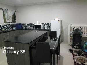 辛加东卡Two Bedroom Holiday Home- Olosara Sigatoka Guest House的厨房配有黑色台面和冰箱