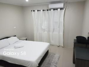 辛加东卡Two Bedroom Holiday Home- Olosara Sigatoka Guest House的卧室配有白色的床和窗户。
