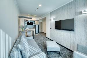 埃里温Expocore Hotel的客厅配有沙发和墙上的电视
