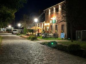 Groß QuassowPension & Gasthof Storchennest的夜幕降临的鹅卵石街道