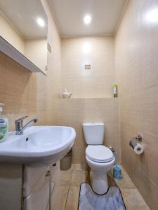 阿斯塔纳Квартира的浴室配有白色卫生间和盥洗盆。