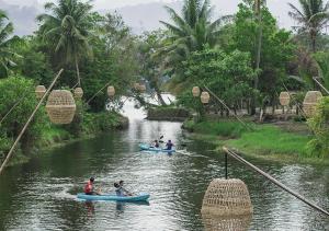 贡布Peam Snea Resort的一群人划船沿着河