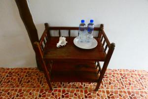 Ban Ao YaiAo Yai Homestay的木椅,盘子上装有两瓶水