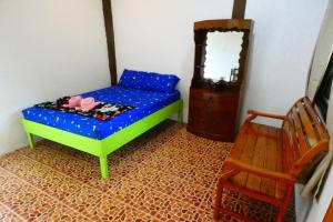Ban Ao YaiAo Yai Homestay的一间小卧室,配有一张床和一把椅子