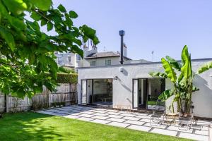 切尔滕纳姆Gorgeous 1BD Balearic-style home with Gardens的白色的房子,有绿草的院子