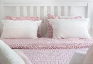 雅典Cosy Apartment With Acropolis View的一张带粉色和白色床单及枕头的床