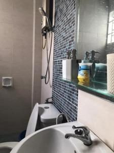 马六甲Homestay Ruma Melaka的一间带水槽、卫生间和镜子的浴室