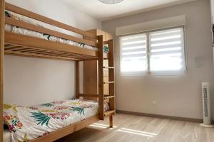 帕拉瓦莱弗洛Appartement calme, climatisé 3min à pied de la mer的一间卧室设有两张双层床和一扇窗户。