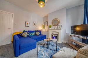 卡斯尔福德Liquorice Lodge- 2 bed & parking的客厅配有蓝色的沙发和电视