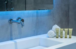 Provatas黄金米洛斯海滩酒店的浴室配有水槽、水龙头和毛巾