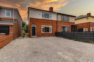 巴恩斯利The Collier's Rest: 3 bed home in South Yorks with parking & garden.的前面有车道的砖房