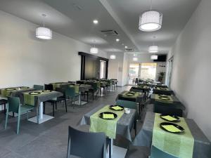 科马基奥Hotel Paradiso的用餐室配有绿色的桌椅