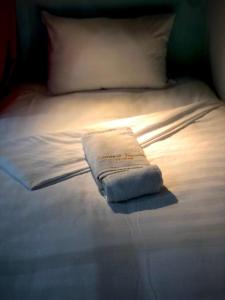 岘港Central Beach Hotel的一张白色的床,上面有一条折叠毛巾
