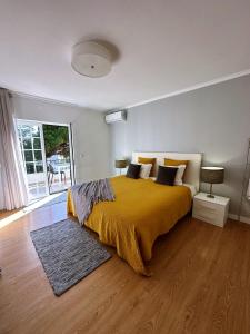 卡斯卡伊斯Moro's Friends House - Cascais的一间卧室配有一张带黄色毯子的大床