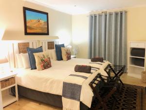 阿多Adrenalin Addo Manor House的卧室配有带蓝色枕头的大型白色床