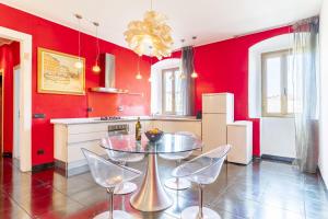 利沃诺Steel house的厨房设有红色的墙壁和桌椅