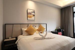 吉隆坡M101 KLCC KL city King Suites by Livin的天鹅装饰,在旅馆房间床上