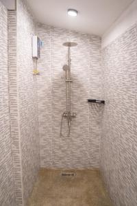 拜县K-Bunk Hostel Pai Walking Street的带淋浴的浴室(带瓷砖墙)