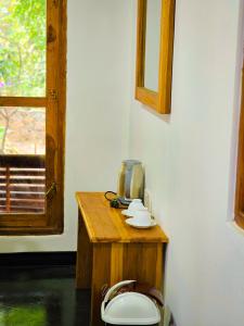 达瓦拉维Sunbird's Home的一间带卫生间的浴室,配有木桌和窗户
