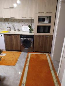 纳希切万House in Nakhchivan city, Azerbaijan的厨房配有洗衣机、水槽和炉灶。