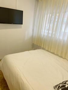 阿尔考本达斯Pensión el Carmen的卧室配有一张床铺,墙上配有电视