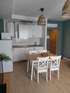 曼萨纳雷斯DIVINA GUEST HOUSE的厨房配有木桌和白色橱柜。