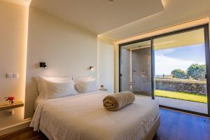 蓬塔德尔加达Quinta das Camélias - Açores的一间卧室设有一张床和一个大窗户