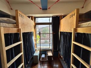 东京Hostel Bedgasm的客房设有三张双层床和一扇窗户。