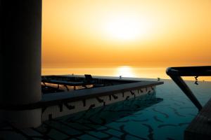 马斯喀特W Muscat的水中的小船,背景是日落