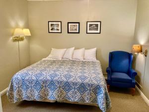 GardenGarden Grove Retreat & Lodging near Pictured Rocks, Fayette, Trails的一间卧室配有一张床和一张蓝色椅子