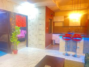 伊斯兰堡Viceroy Luxury Hotel Apartments Islamabad的一间厨房,里面设有两个红色凳子