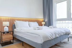 拉斯阿尔卡麦Luxurious Golf View & 1BD & Brand New Listing的卧室配有一张白色大床和木制床头板