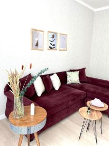 阿斯塔纳Park Avenue High Comfort 102-2的客厅配有红色的沙发和2张桌子