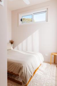 凯阿玛Heights Guesthouse - Hideaway in Kiama Heights的白色的卧室设有床和窗户