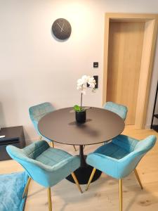 维也纳Design Apartment Vienna City Center - free parking!的一间带桌子和蓝色椅子的用餐室