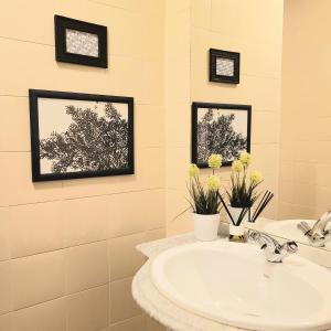 HOSTEL Villanueva的一间带水槽的浴室和墙上的两张照片