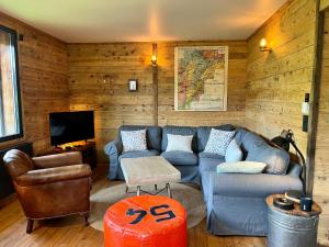 莱鲁斯Chalet Vieux Bois, au coeur du village des Rousses的客厅配有蓝色的沙发和电视