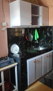内罗毕Elegantly furnished 1bedroom at Claycity, Thika Rd的厨房配有黑色台面和水槽